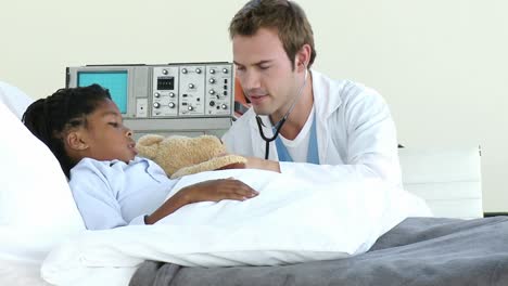 un doctor guapo examinando a un niño pequeño.