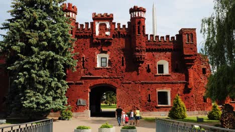 brest, belarus. people tourists walking near outside outdoor facade of the kholm gate gates of the brest fortress. memorial complex brest hero fortress in sunny summer day