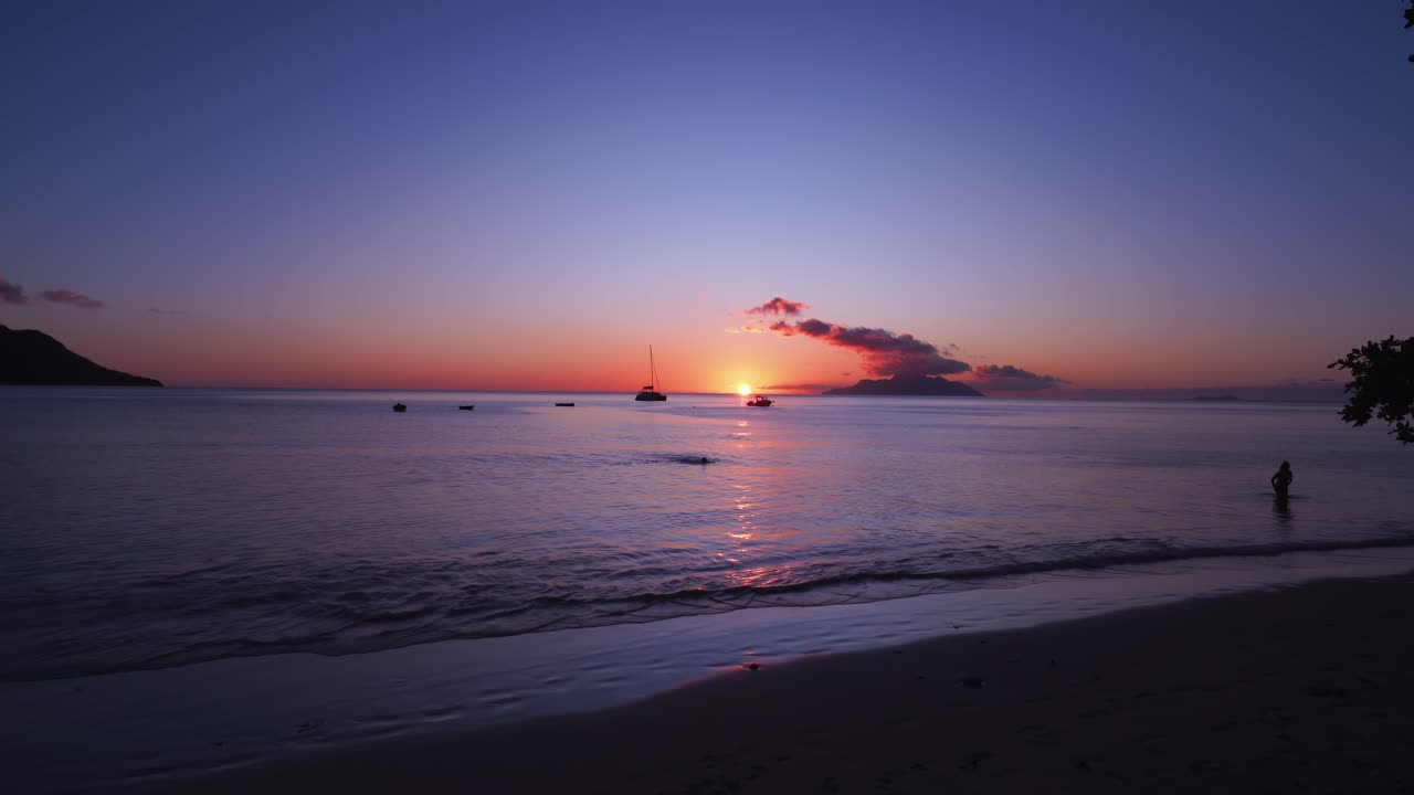 beautiful sunset on beau vallon beach, Mahe Seychelles, tourist swimming, calm sea and beautiful scenery