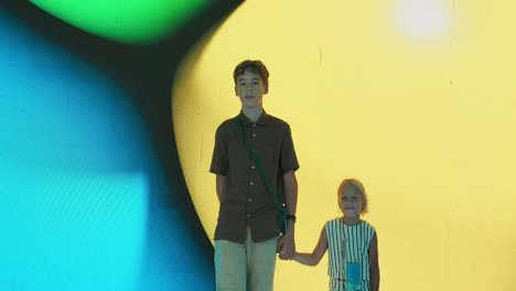 children holding hands in front of colorful background