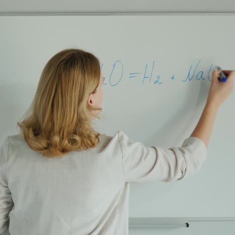 Woman-Writes-Chemical-Formulas-On-Board
