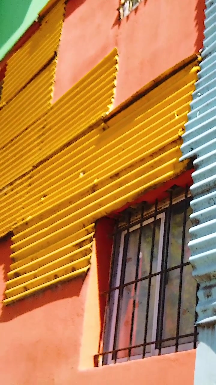 Vertical Low Angle Vibrant Orange Yellow Corrugated Houses in Caminito La Boca Buenos Aires Argentina