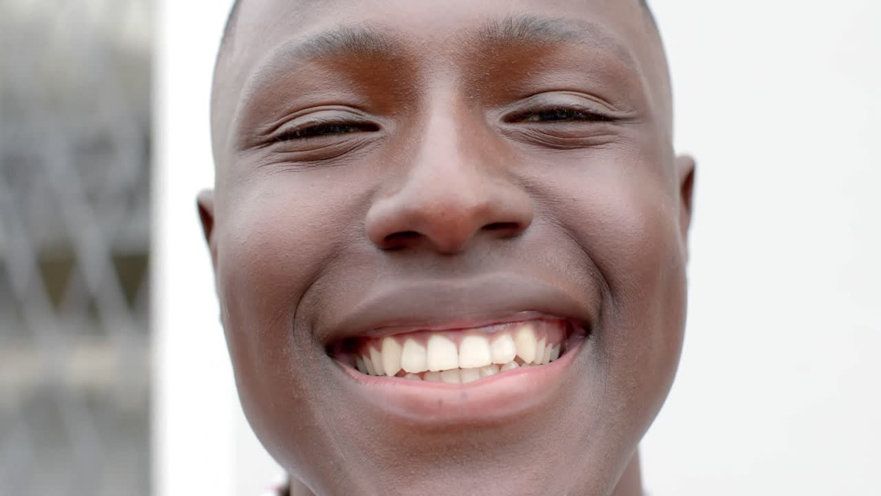 Ritratto di uomo afroamericano felice che guarda in camera a casa, al rallentatore