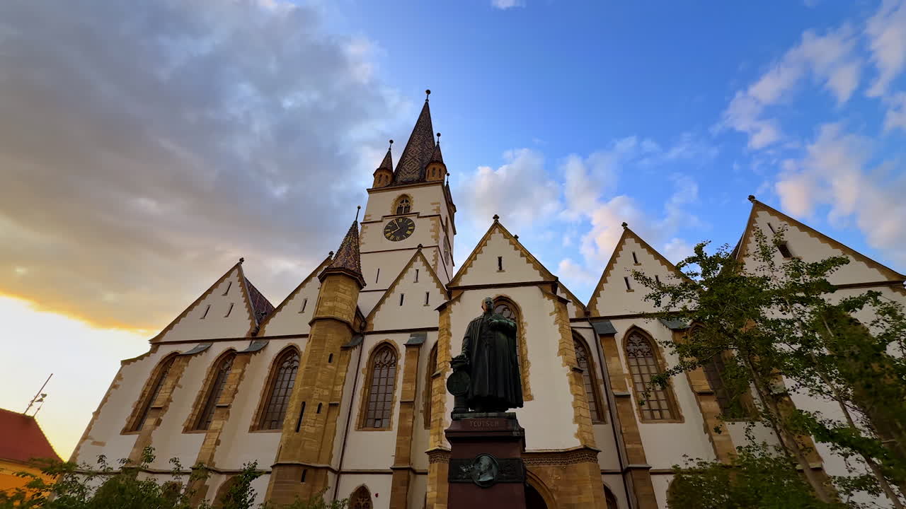 Sibiu, Romania, 17 July 2025: Approaching the statue in front of the Lutheran Cathedral of Saint Mary in Sibiu, Romania. Low angle view. Cloudy sky at backdrop