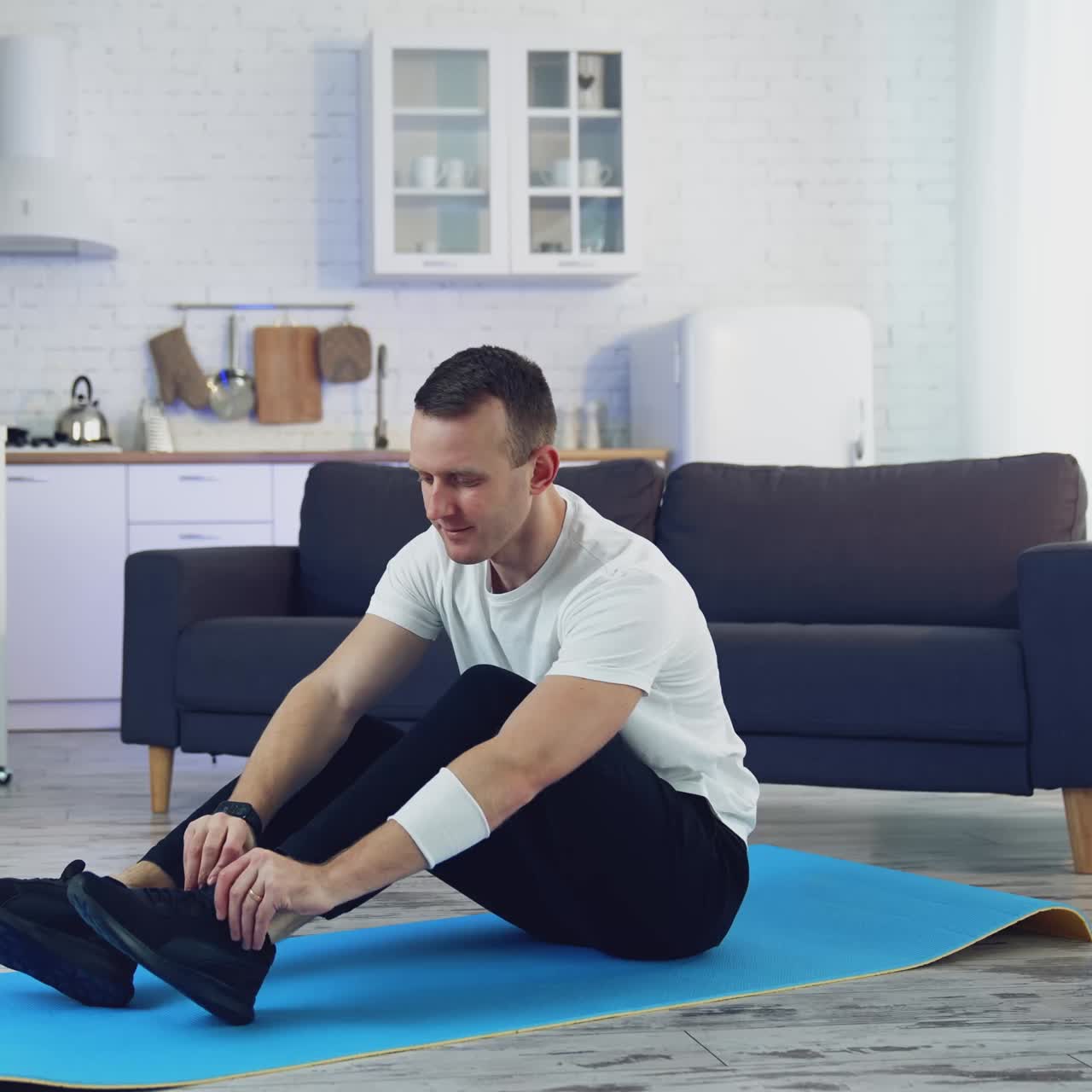 Man during workout at home. Young man doing exercising in living room at home