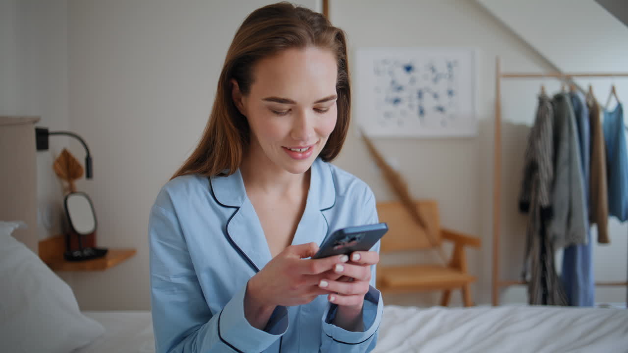 Morning woman browsing cellphone in bed at weekend closeup. Girl looking screen