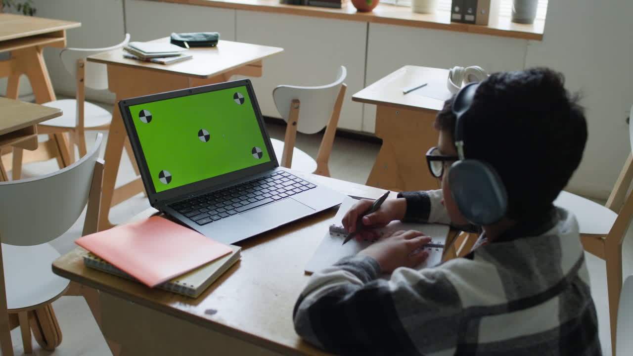 estudiante trabajando en una computadora portátil en el aula