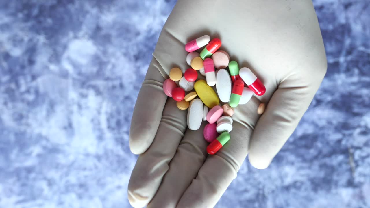 un puñado de pastillas en guantes médicos