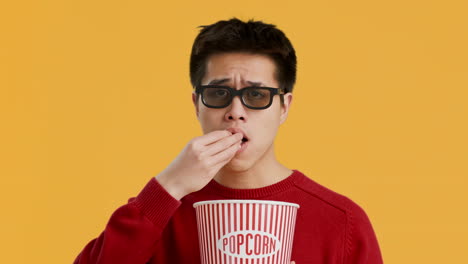 young man watching a movie with popcorn