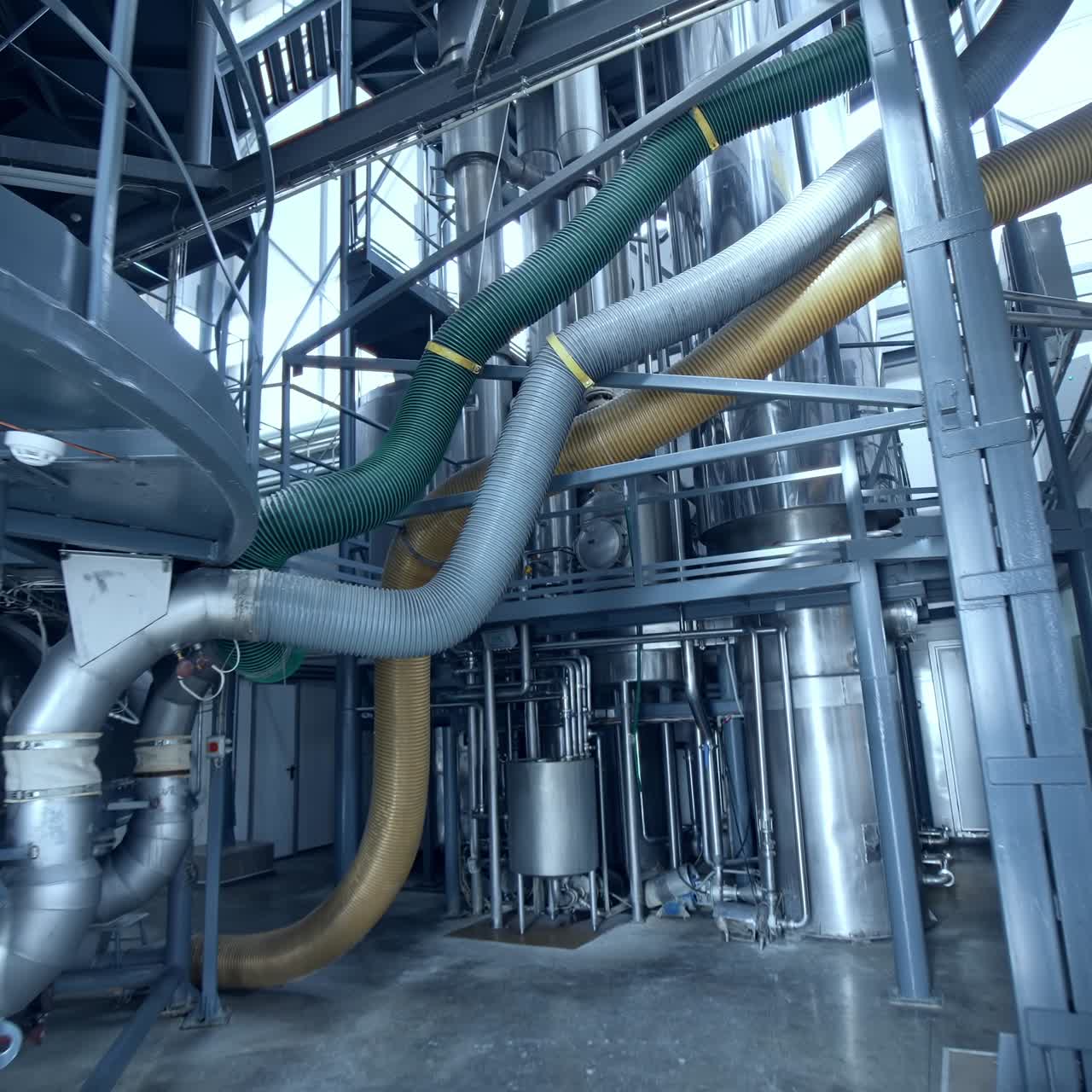 Innovative technological equipment for milk products manufacturing. Steel tubes and tanks at the dairy enterprise. Circle movement around the plant, view from below