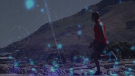 Animation-of-blue-spots-falling-over-african-american-fit-man-running-on-the-beach