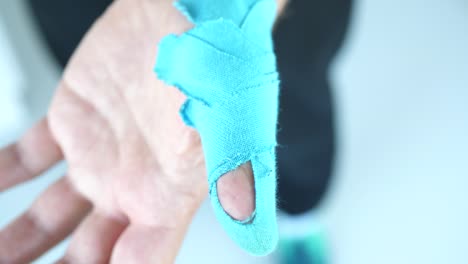 man showing kinesiology taping on his thumb