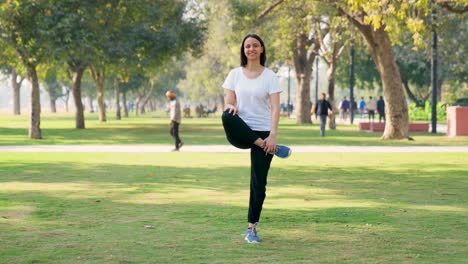 mujer india haciendo ejercicio de calentamiento en un parque por la mañana