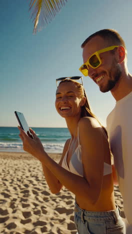 happy couple on beach looking at phone