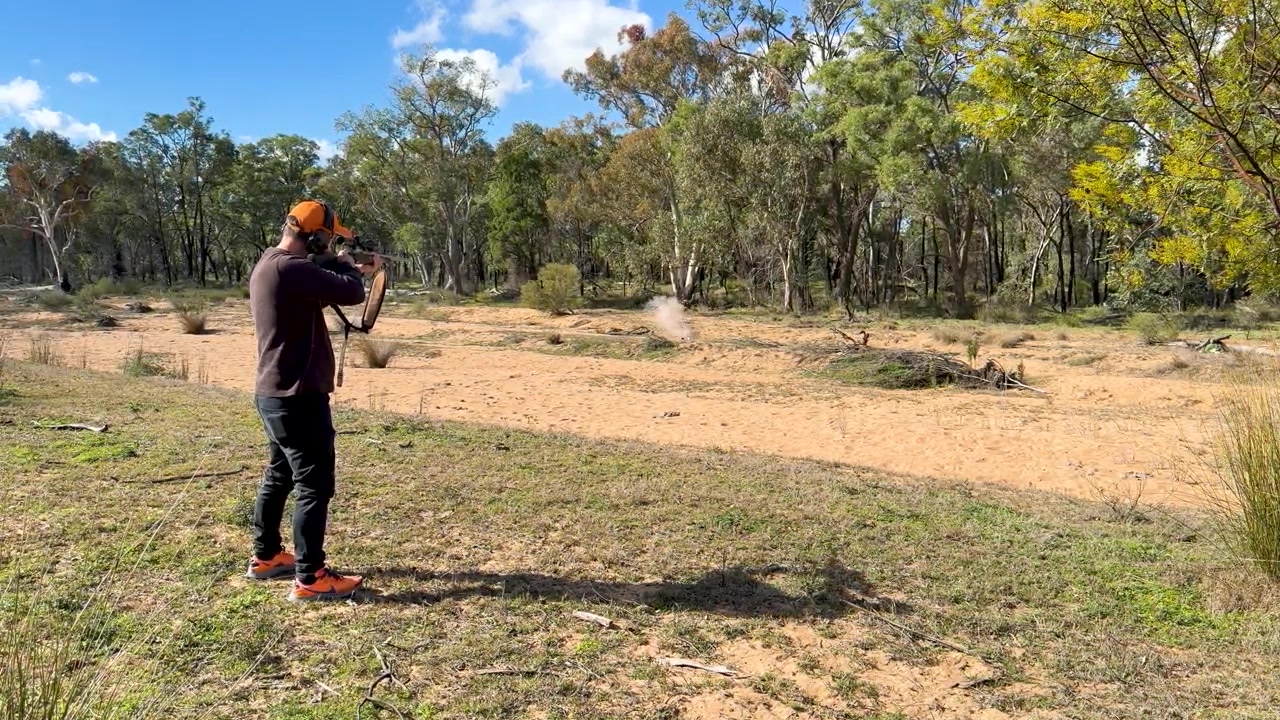 Man Practicing Archery in an Open Field
