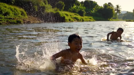 young boys playing and splashing in a river