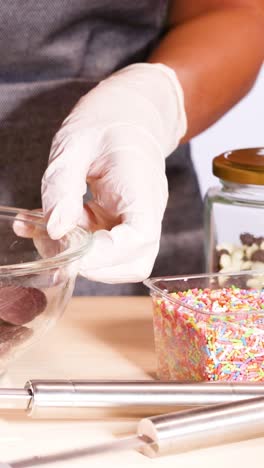 manos preparando discos de chocolate con ingredientes de colores