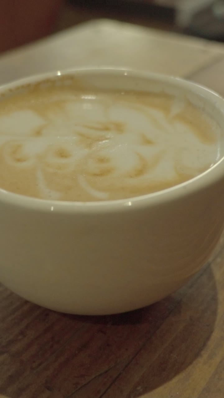 Un latte cremoso in un'accogliente caffetteria, che evoca calore e relax.