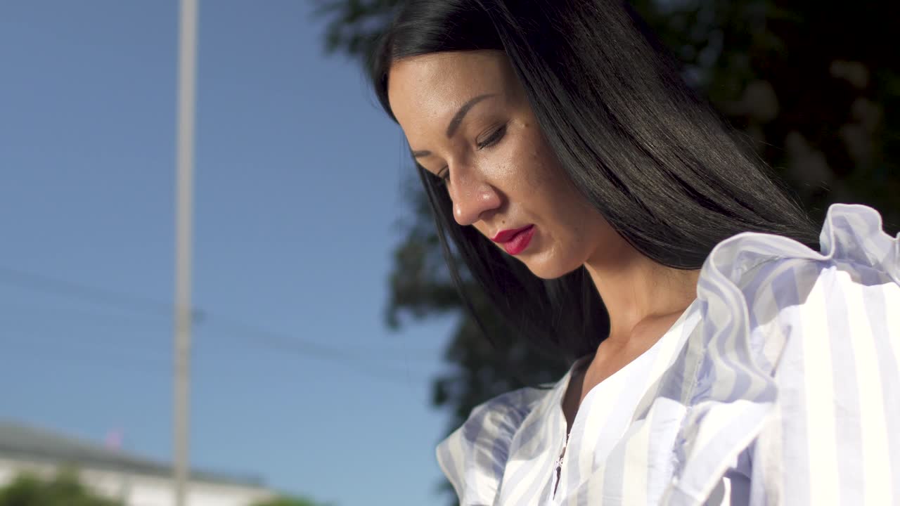 Stylish woman in white blouse answering the call on her phone
