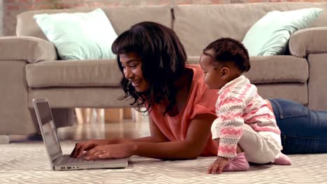 Mother-using-computer-with-her-baby-