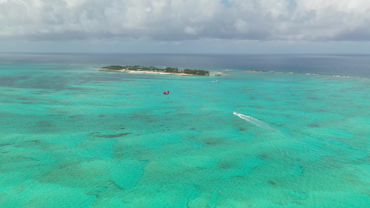 Nassau, Bahamas. Drone Aerial View of Parasailing Parachute and Boat in Emerald Sea Water