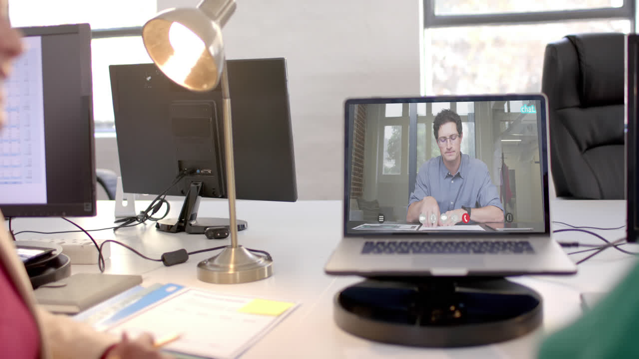 Laptop with video call with caucasian businessman on screen
