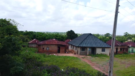 pullback aerial revealing metal-roof homes and wires across urban ibadan neighborhood