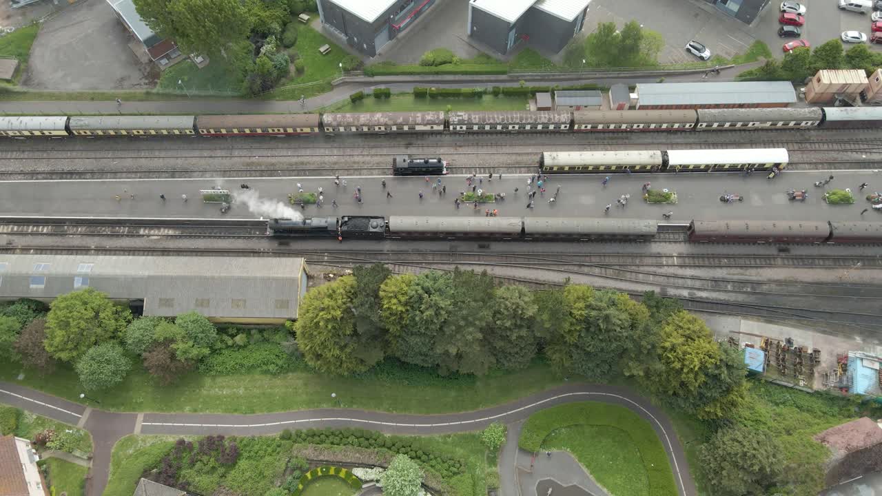 Aerial view of the Minehead steam railway station England's longest heritage line, running 20 miles between Minehead and Bishops Lydeard. Drone over a parked steam train, other moving to the right