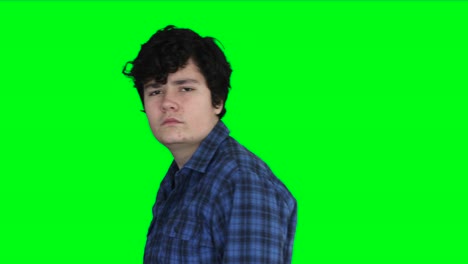 teenage boy looking seriously with green screen background