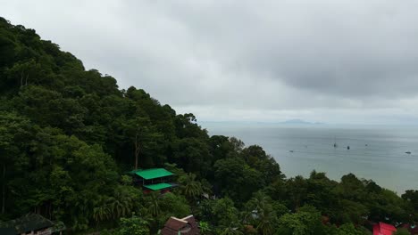 a scenic view of a lush green hillside overlooking a calm sea under a cloudy sky, with boats scattered in the water.