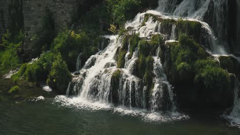 una cascada panorámica que cae en cascada sobre las rocas cubiertas de musgo en rastoke, croacia