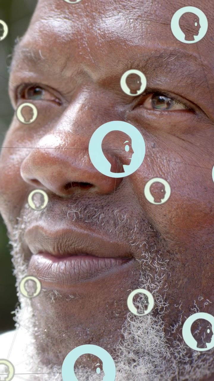 Vertical video: Senior man turning to offscreen cue, blue head circles over face showing tech data