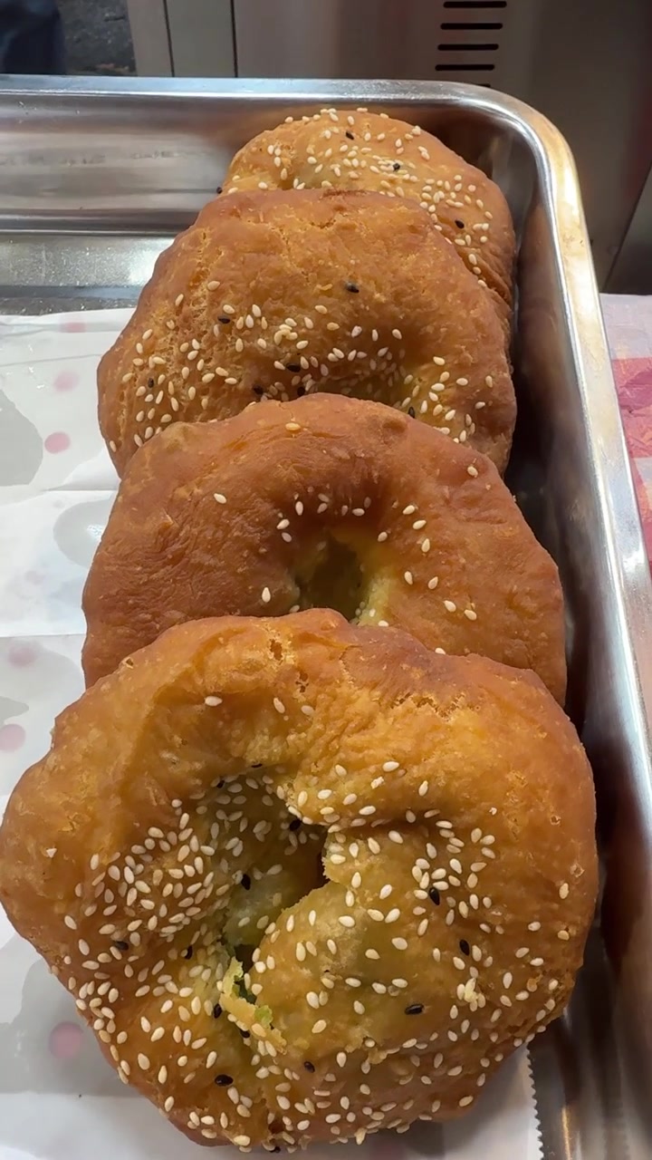 Ciambelle al sesamo appena fritte su un vassoio di metallo