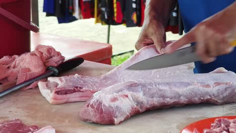 cutting pork belly at a market