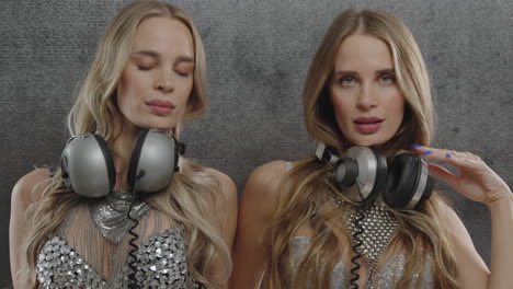 identical twin female dancers in sparkling silver costumes