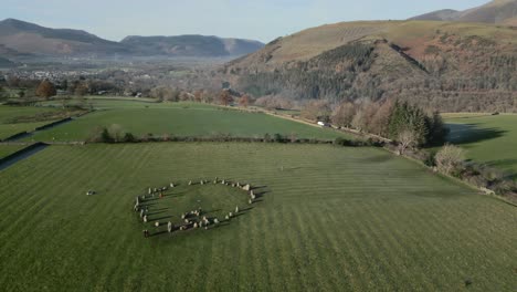 ancient stone circle with high orbit revealing town of keswick and surrounding mountain ranges