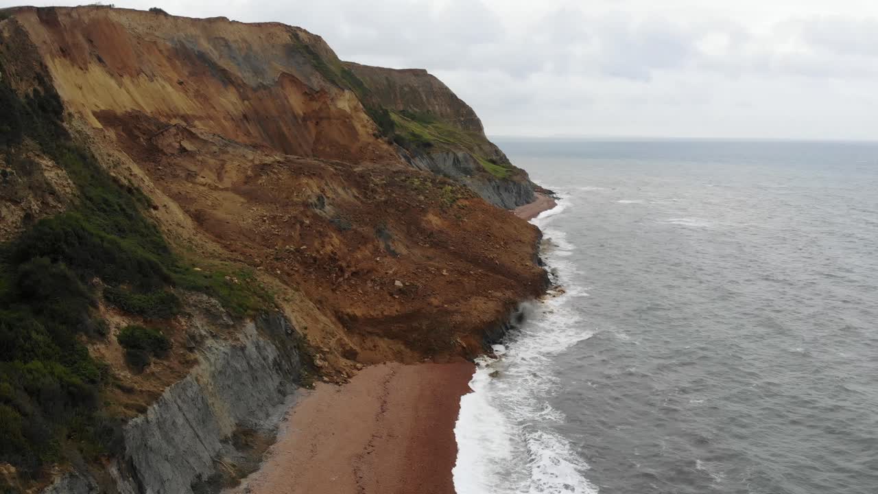 vista aérea a lo largo de la caída de un gran acantilado costero en la playa de seatown