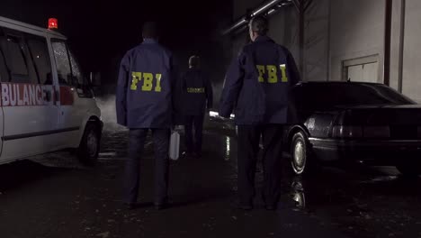 fbi and coroner at a crime scene at night