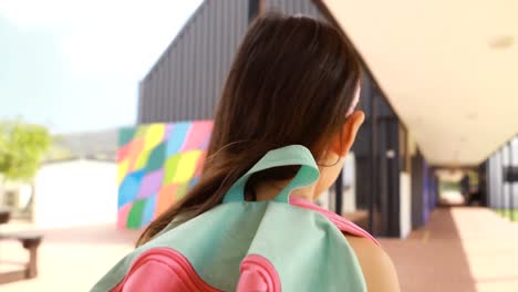 rear view of schoolgirl with backpack walking in corridor 4k