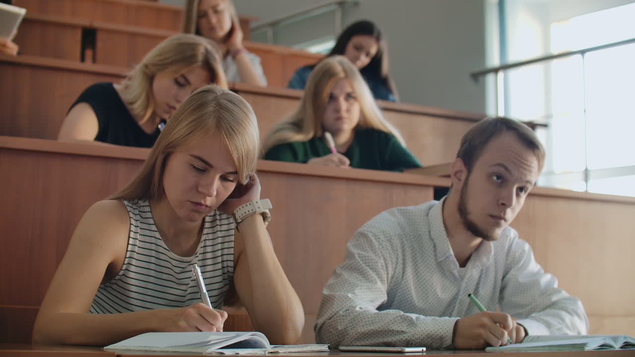 jóvenes estudiantes exitosos en una gran clase universitaria escuchan y graban una conferencia una conferencia real en la universidad.