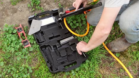 Man-loading-pneumatic-nail-gun-before-start-working,-close-up