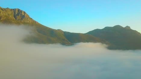 Drone-aerial-above-the-clouds-looking-at-Table-Mountain-and-Twelve-Apostles-behind-Cape-Town-South-Africa