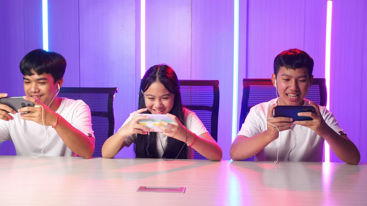 Team Of Asian Esport Gamers Playing In Competitive Video Games On A Cyber Games Tournament By Mobile Phone