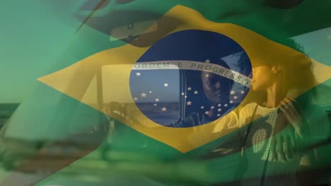 animation of brazilian flag waving over romantic african american couple traveling in pick-up truck