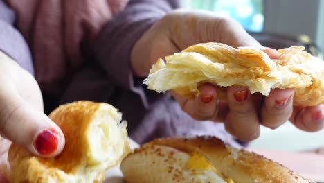 una mujer comiendo un croissant.
