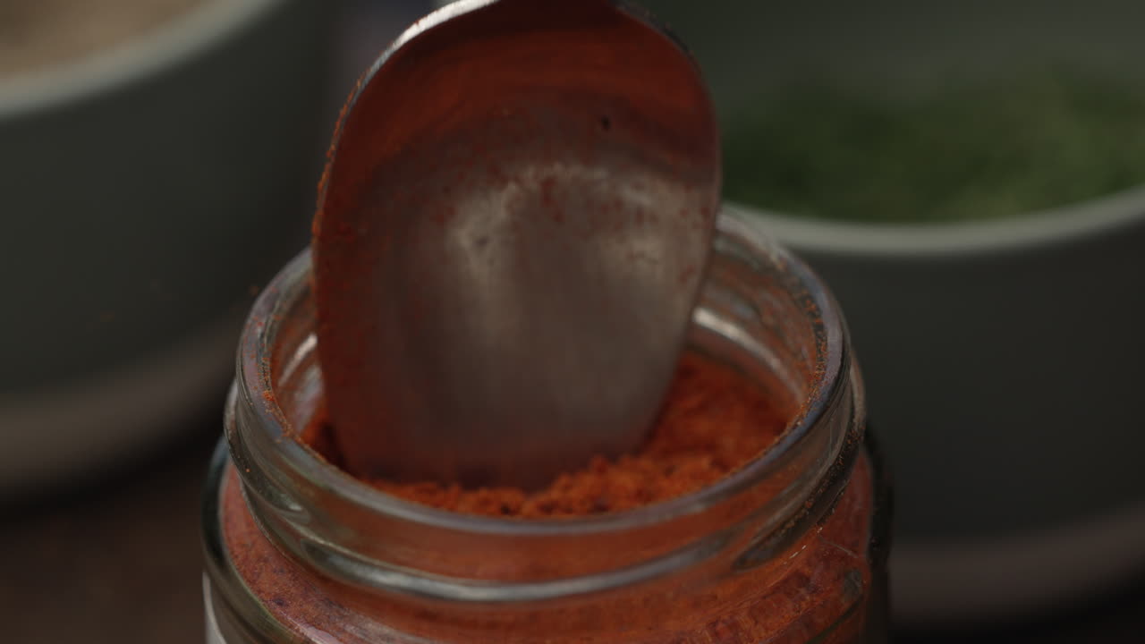 зачерпывание порошка паприки с помощью столовой ложки