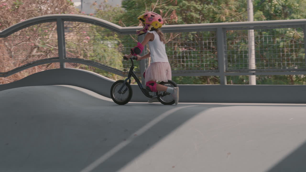 niño montando bicicleta en una arena de patinaje cubierta