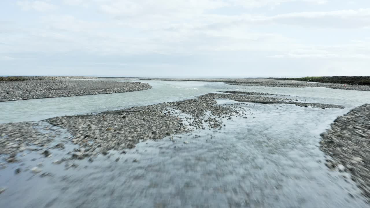 volando bajo un puente con agua glacial fría llena de minerales en islandia