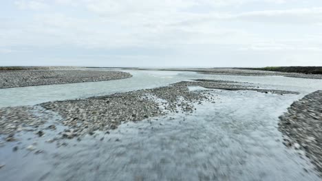 flying under bridge with cold glacial water filled with minerals in iceland