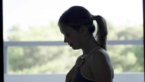 Side-view-of-calm-beautiful-woman-practicing-breath-exercises